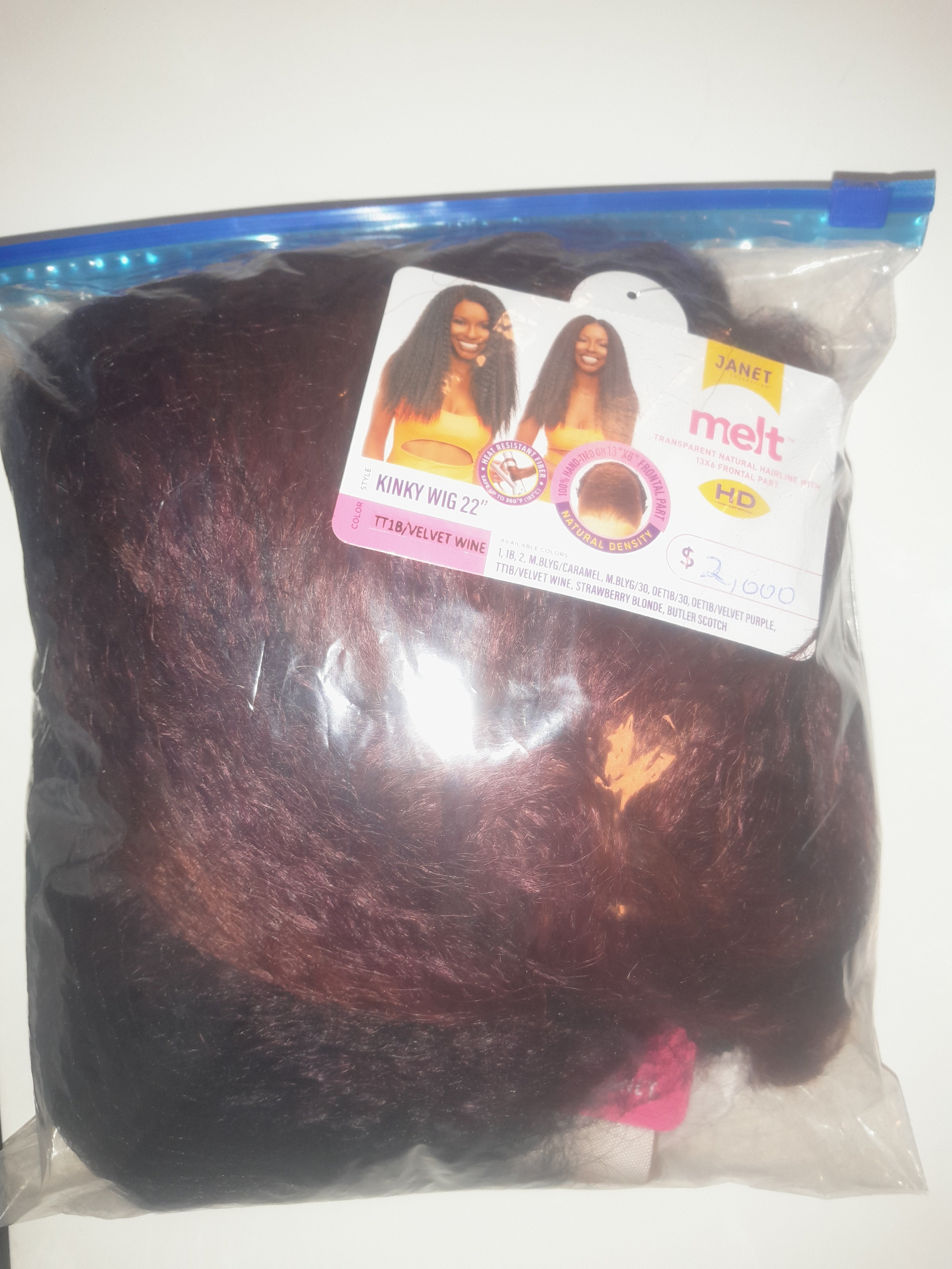 Lång curly peruk i burgundy ombre med naturligt hårfäste, mittbena och definierade lockar för fyllig volym i förpackning.