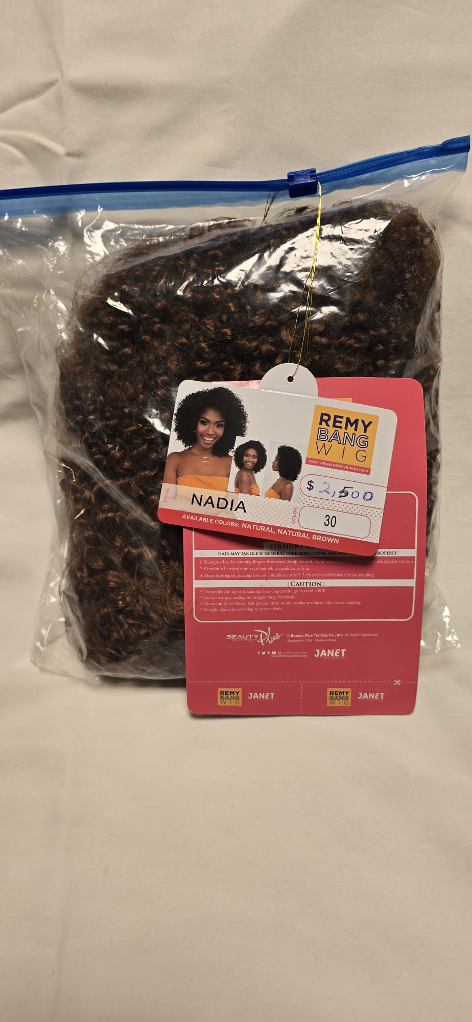 Peruk i äkta Virgin Remyhår med fylliga naturliga lockar i Natural Brown, afroinspirerad stil och naturligt hårfäste i orginalförpackning.